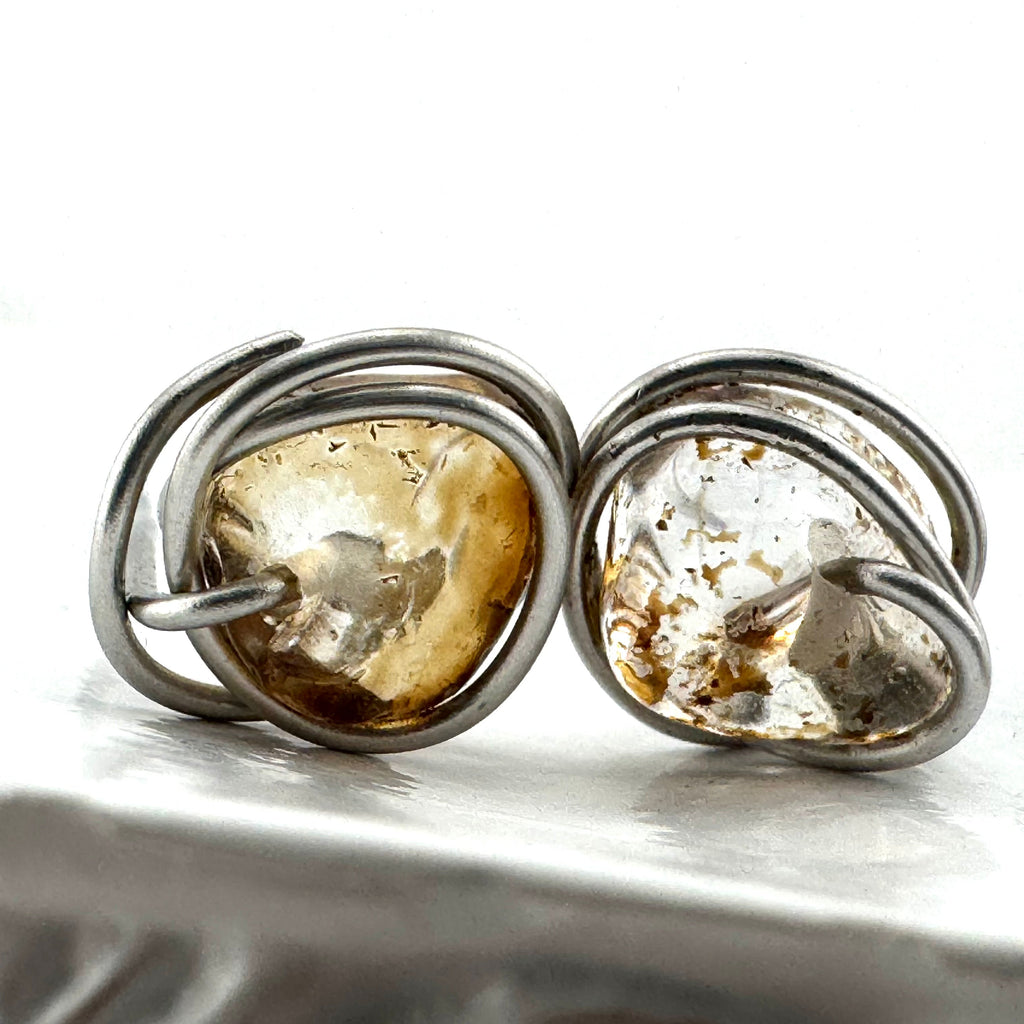 A pair of sitainless steel wire-wrapped earrings featuring natural, irregularly shaped quartz stones with warm golden-brown natural inclusions, shown on a white surface.