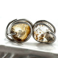 A pair of sitainless steel wire-wrapped earrings featuring natural, irregularly shaped quartz stones with warm golden-brown natural inclusions, shown on a white surface.