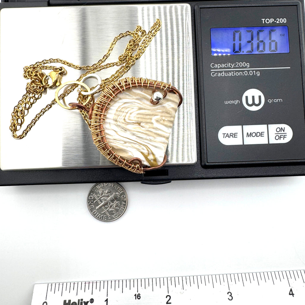A gold chain necklace with a large clay pendant is shown resting on a digital scale, with a dime and ruler below for scale. The scale display reads .366 oz.